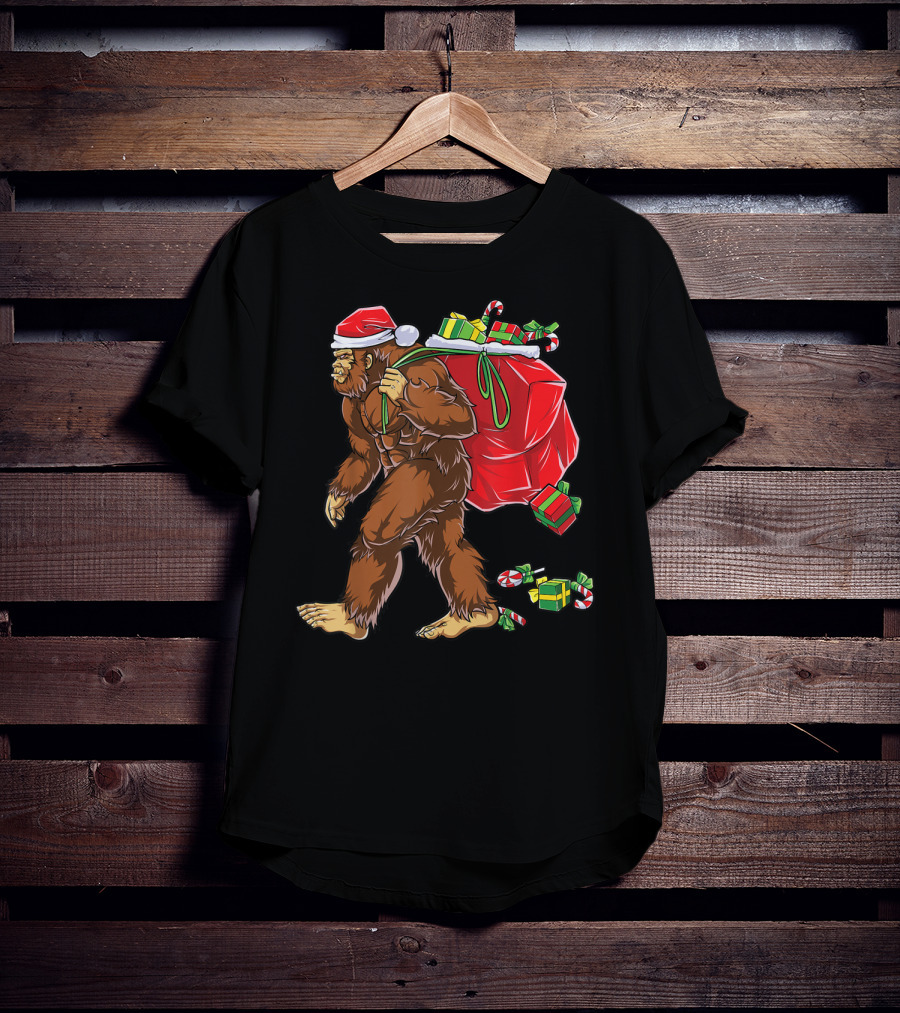 Bigfoot Santa With Giant Red Christmas Bag And Green Gifts Wearing Xmas Hat T-Shirt
