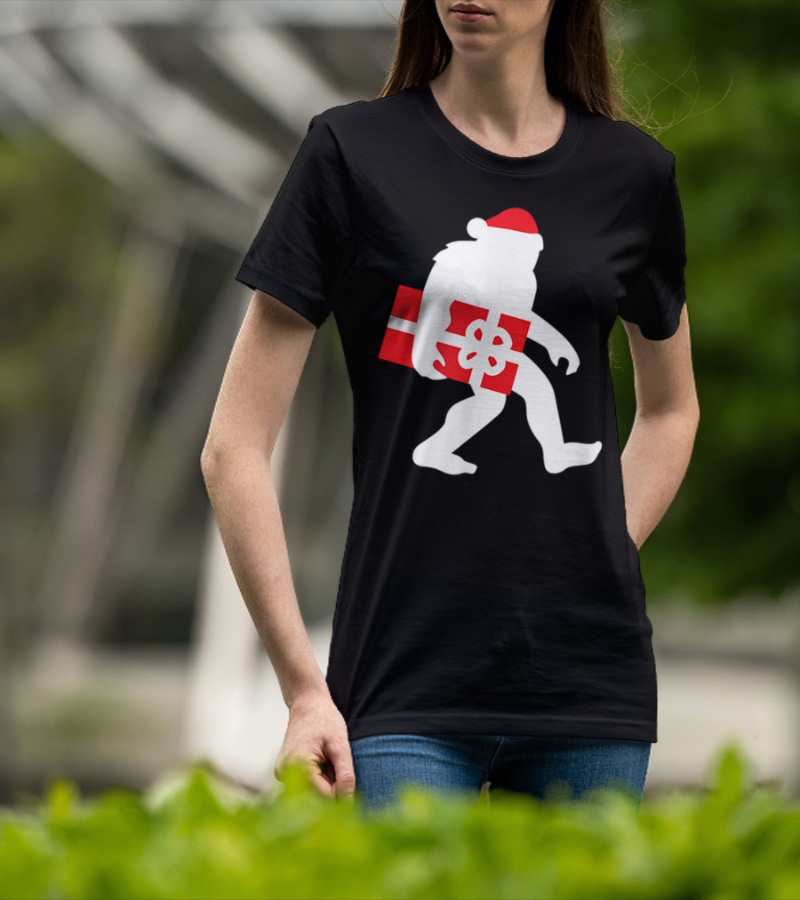 Nice Bigfoot Carrying Christmas Gift In Santa Hat T-Shirt