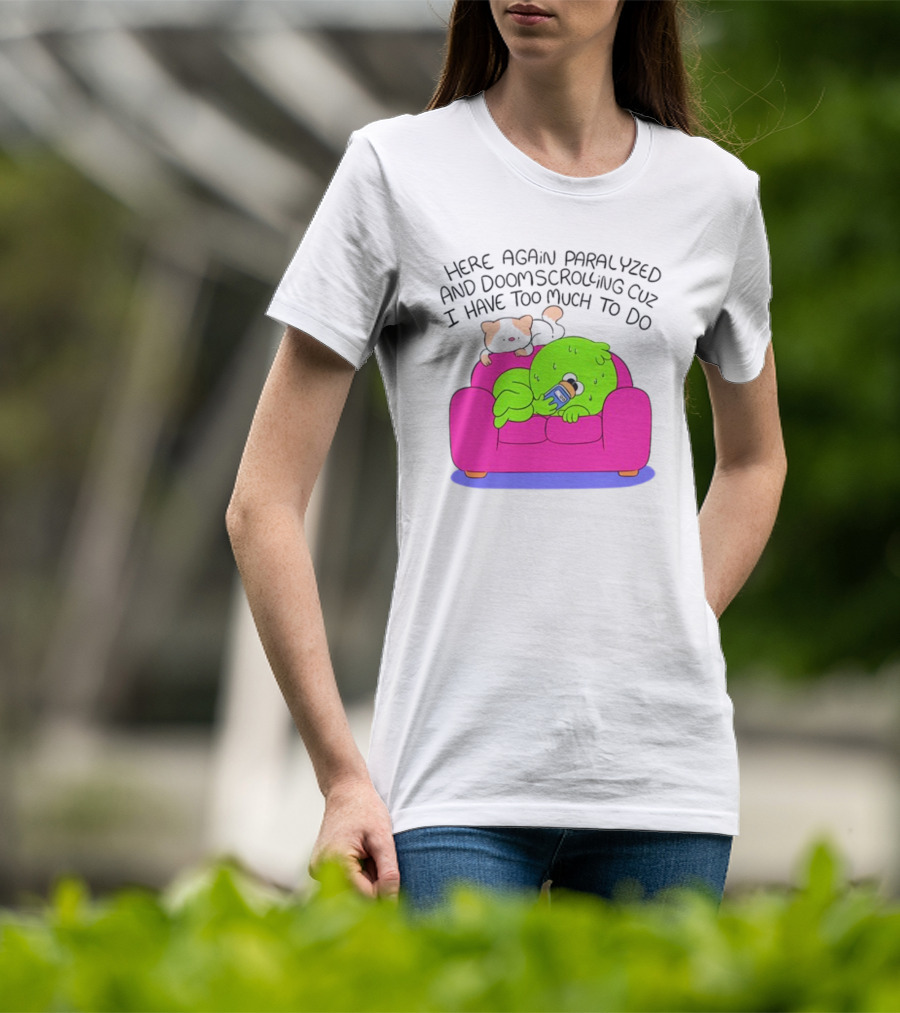 Here Again Paralyzed And Doomscrolling Cuz I Have Too Much To Do Quirky Green Figure Relaxing On Pink Couch With Cute Dog T-Shirt