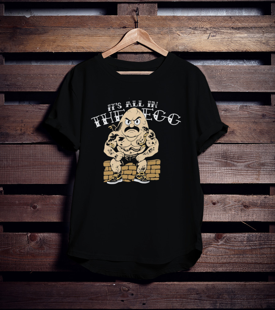 It's All In The Egg Muscular Cartoon Character With Mustache Sitting On Brick Wall T-Shirt