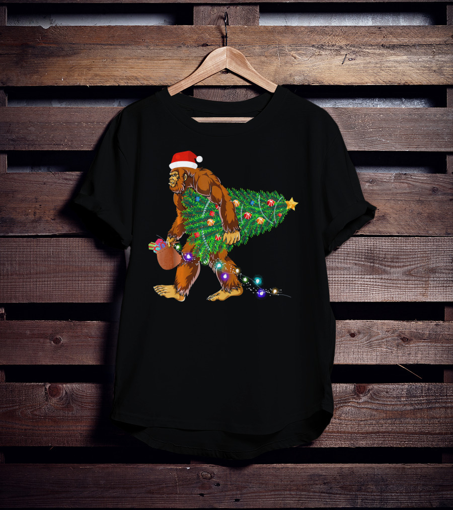Santa Hat Bigfoot Holding Christmas Tree With Lights And Gifts T-Shirt