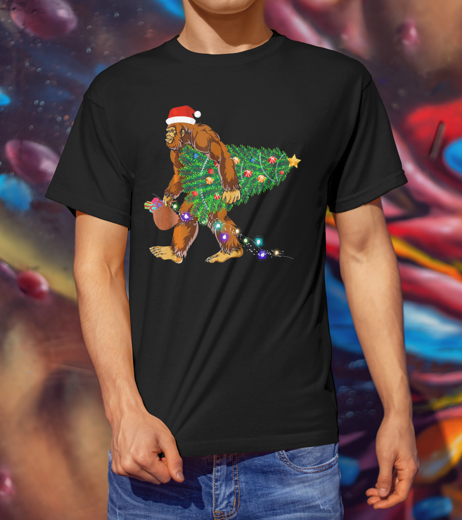 Santa Hat Bigfoot Holding Christmas Tree With Lights And Gifts T-Shirt