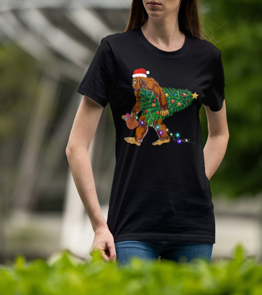 Santa Hat Bigfoot Holding Christmas Tree With Lights And Gifts T-Shirt